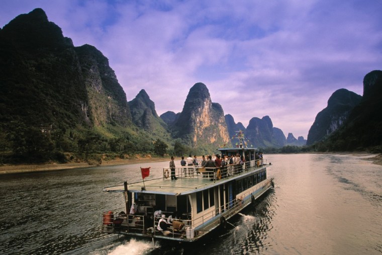 Visitors come to Guilin, China, to explore the city's otherworldly beauty, with the Li River winding through it, and karst rock formations peaking jaggedly among buildings.